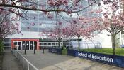 the front entrance of a building with cheery trees in bloom